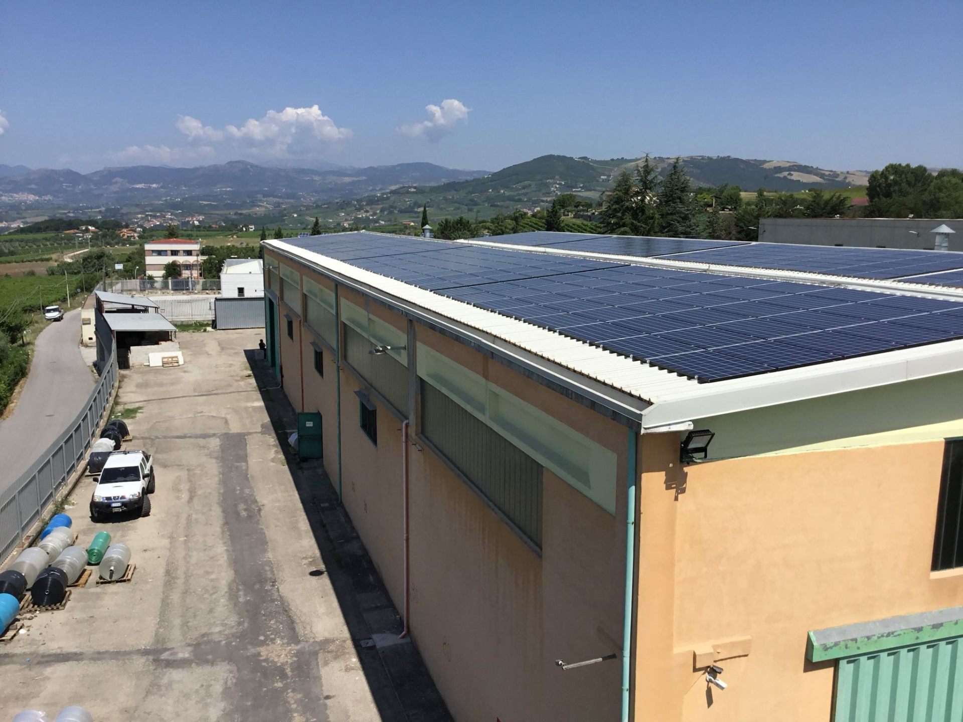 Stabilimento con impianto fotovoltaico e panorama collinare